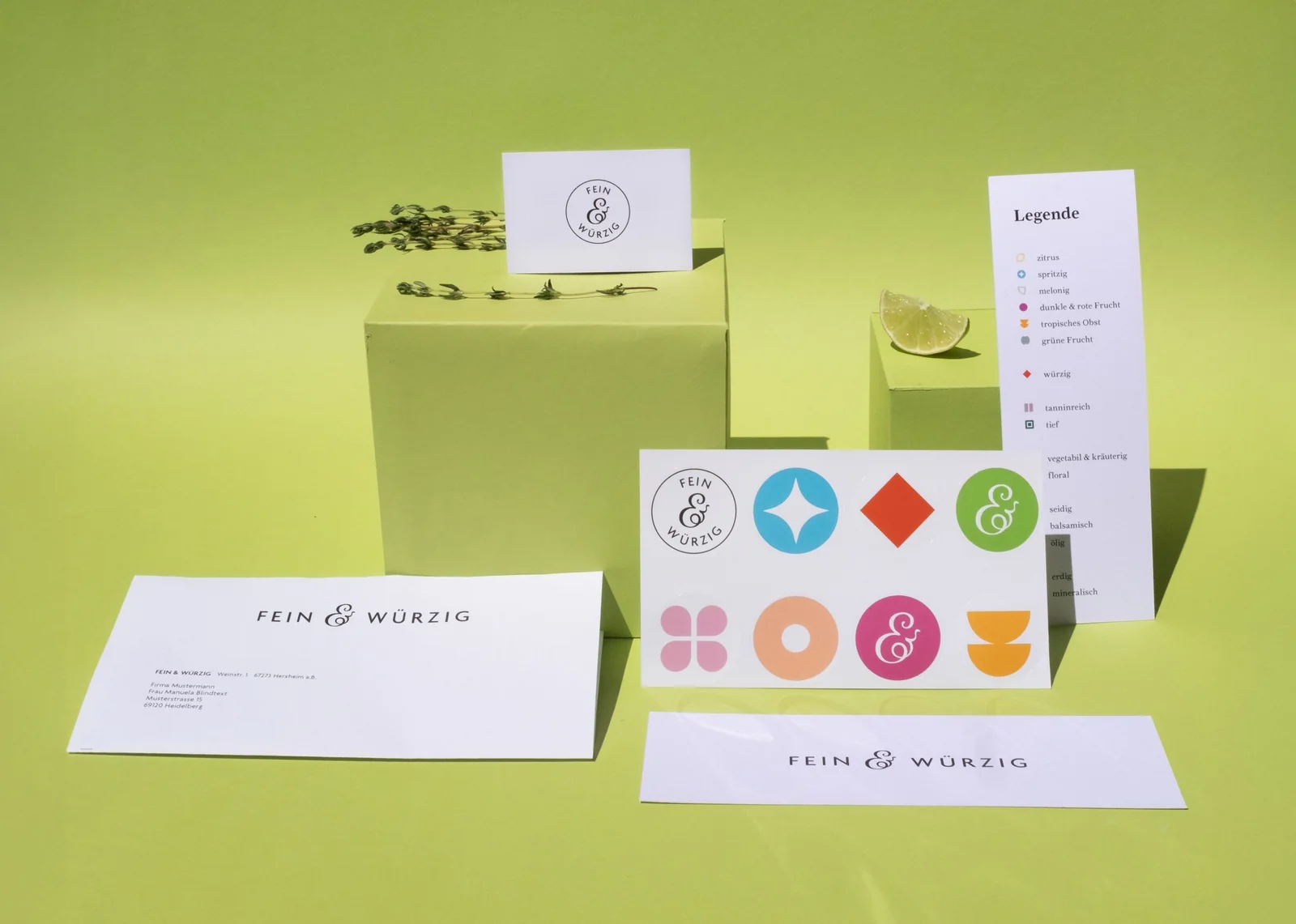 Stationery von Fein & Würzig: Visitenkarten, Briefumschläge und Karten vor grünem Hintergrund